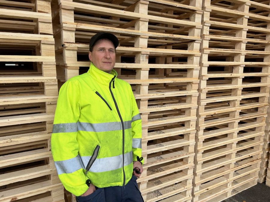Fabian framför lastpallar vid träemballagetillverkningen i Skruv